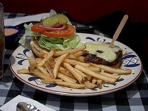 Hamburger and fries served in an American dinn...