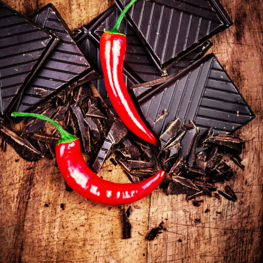 Spicy Chocolate Bar On Wooden Background Closeup. Chunks Of Brok