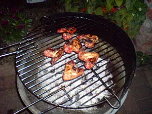Chicken wings being cooked slowly over charcoa... Chicken wings being cooked slowly over charcoa...