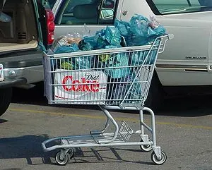 A shopping cart filled with bagged groceries l... A shopping cart filled with bagged groceries l...