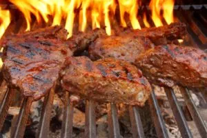 Beef Steak On The Bbq Grill With Flames.