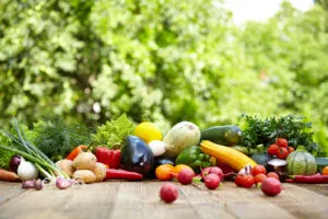 Fresh organic vegetables ane fruits on wood table in the garden
