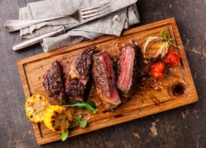 Sliced Medium Rare Grilled Beef Steak Ribeye With Corn And Cherr