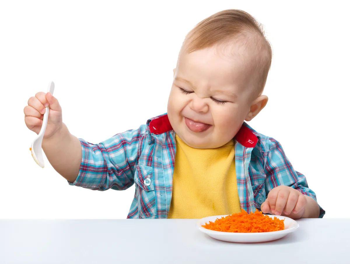 Little boy refuses to eat making unpleasant grimace, isolated over white