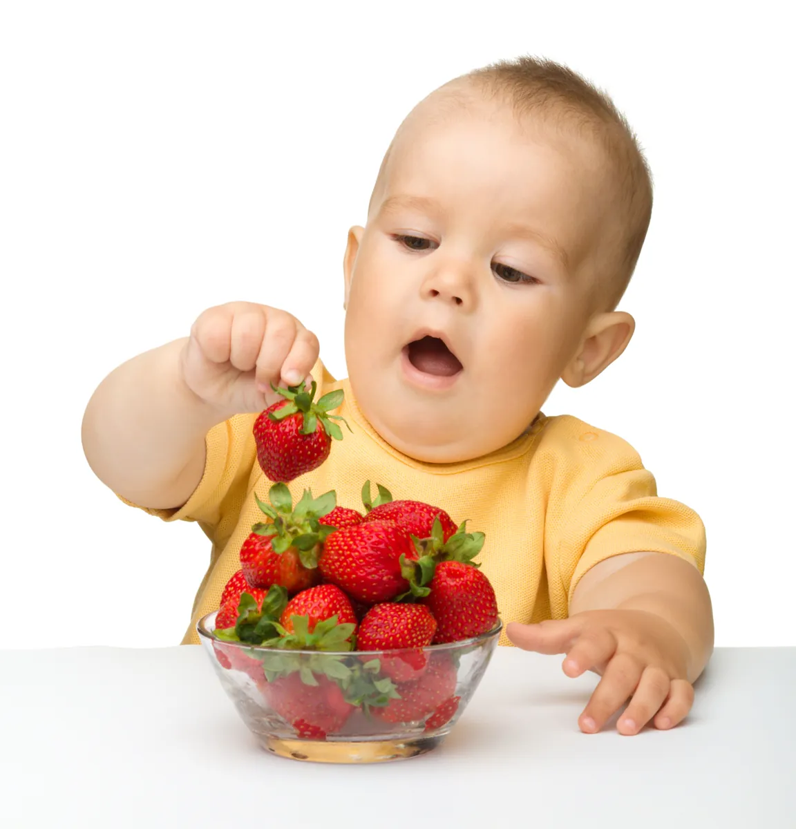 Happy little boy with strawberries, isolated over white