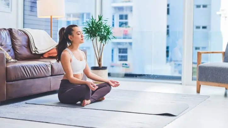 Woman doing yoga on the floor in her family room