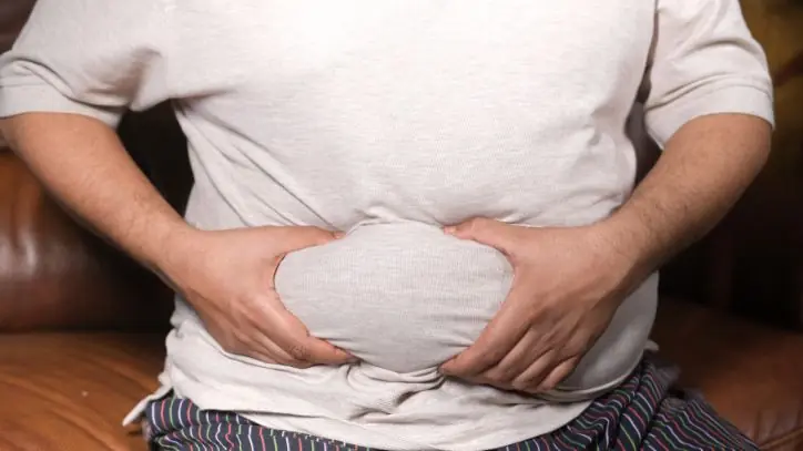 Man grabbing fat on belly