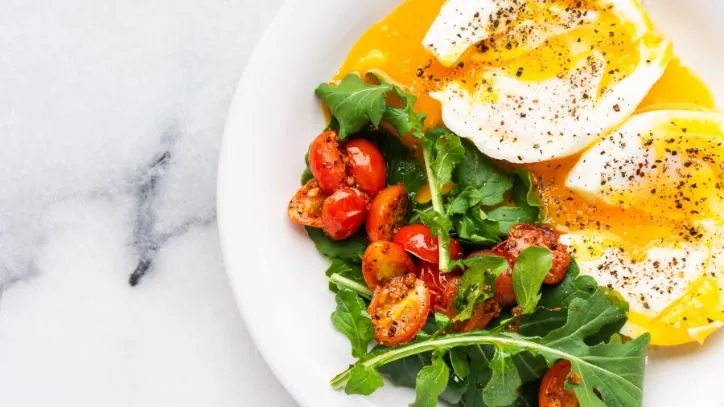 Two soft boiled eggs with spinach and tomatoes