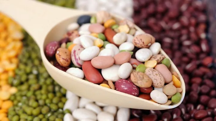 Wooden scoop filled with different types of beans