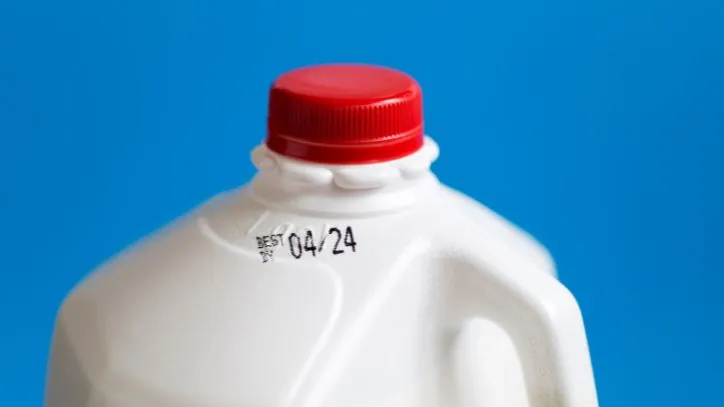 Close up of the top of a gallon of milk, showing the experation date