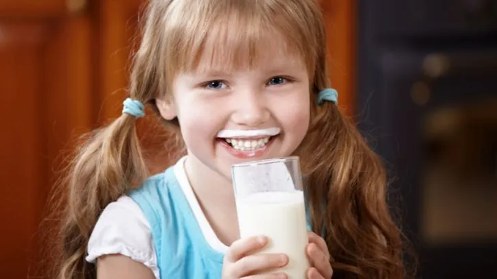 Girl drinking milk and smiling