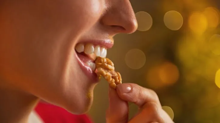 Woman eating a walnut