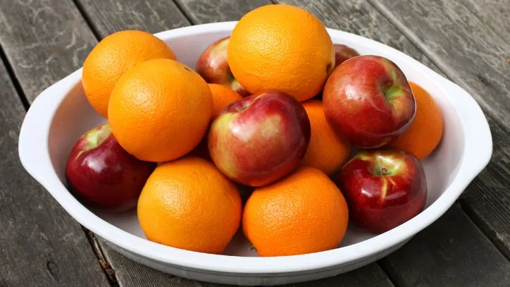white bowl filled with apples and oranges