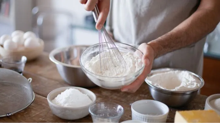 mixing flour in a bowl with a wisk