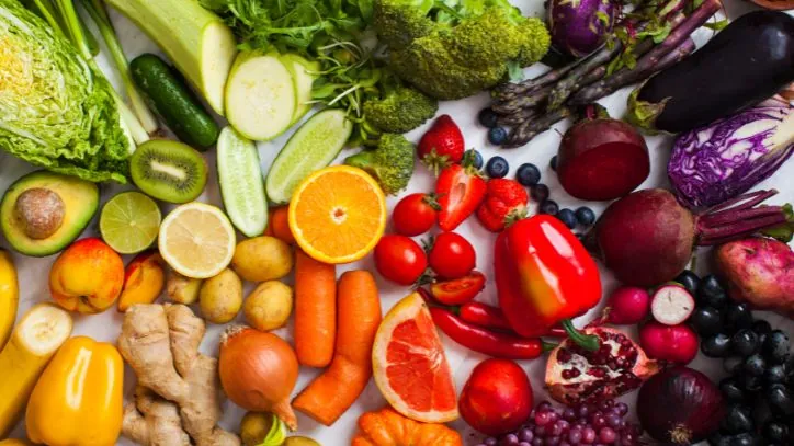 Various colored fruits and vegetables laid out on a countertop