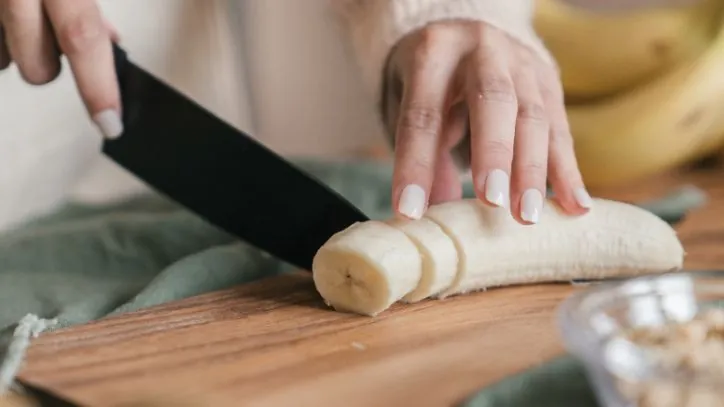 slicing up a banana with a knife