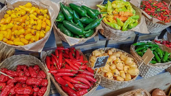baskets of various peppers at a outdoor market