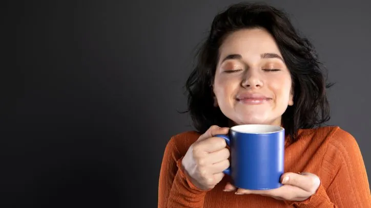 Woman holding a coffee cup while smiling
