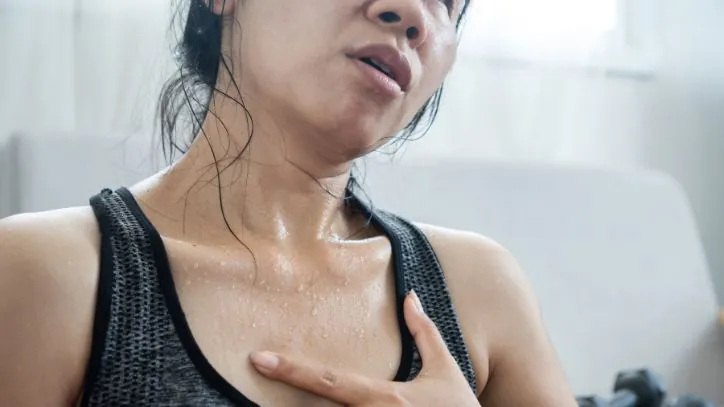 Woman experiencing fatigue and sweating heavily