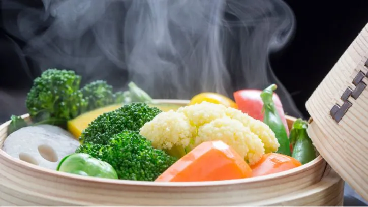 various vegetables sitting in a bamboo steamer