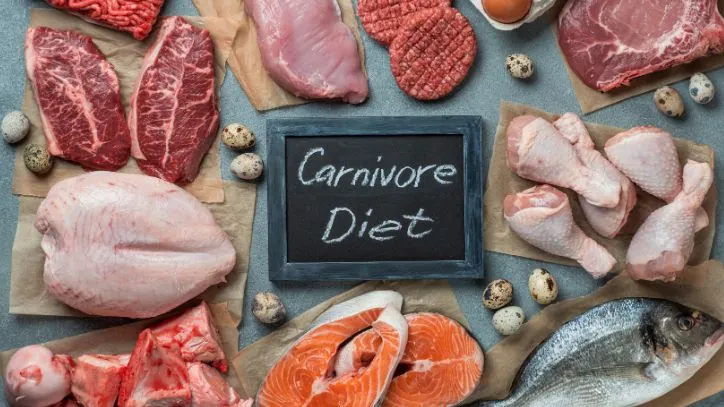 Countertop covered in raw meat and a small chalkboard that says "carnivore diet"