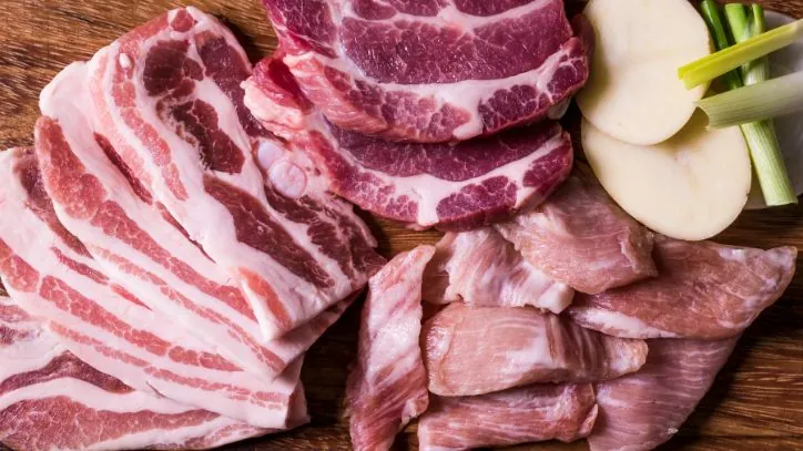 Cutting board covered in multiple different cuts of pork
