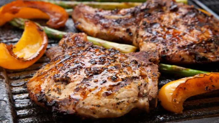 Grilled pork chops and bell pepper on a cast iron pan