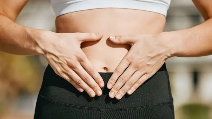 Woman holding her hands in front of her stomach