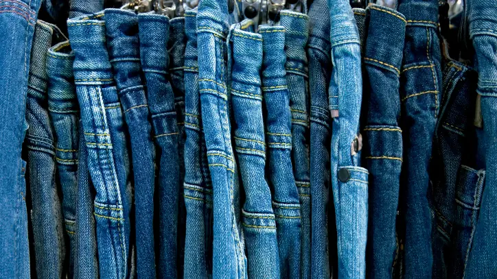 several pairs of denim jeans hanging next to each other